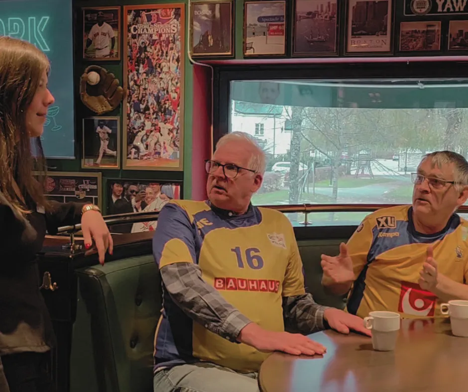 Två quizdeltagare i sporttröjor vid ett bord på O'Learys