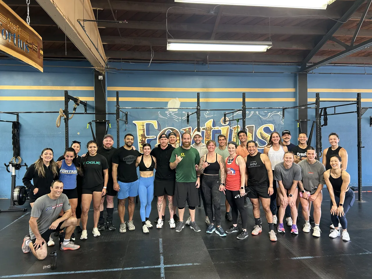 Smiling CrossFit Fortius members and coaches together in the Point Loma gym
