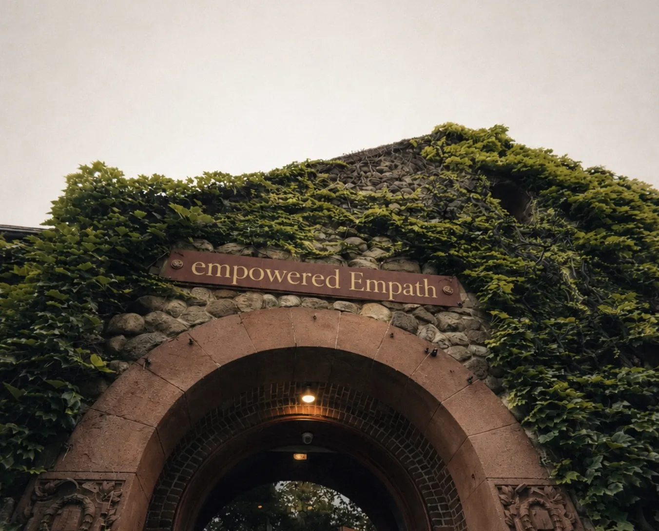 An ivy-covered stone archway with a sign reading empowered Empath