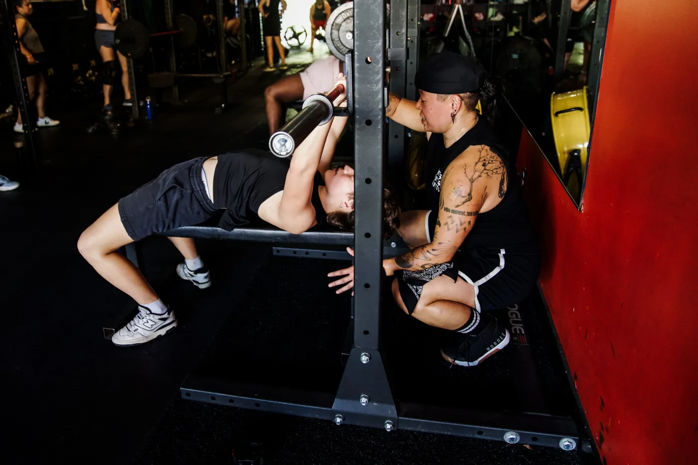 Kai spotting a client on the bench press at The Phoenix Effect