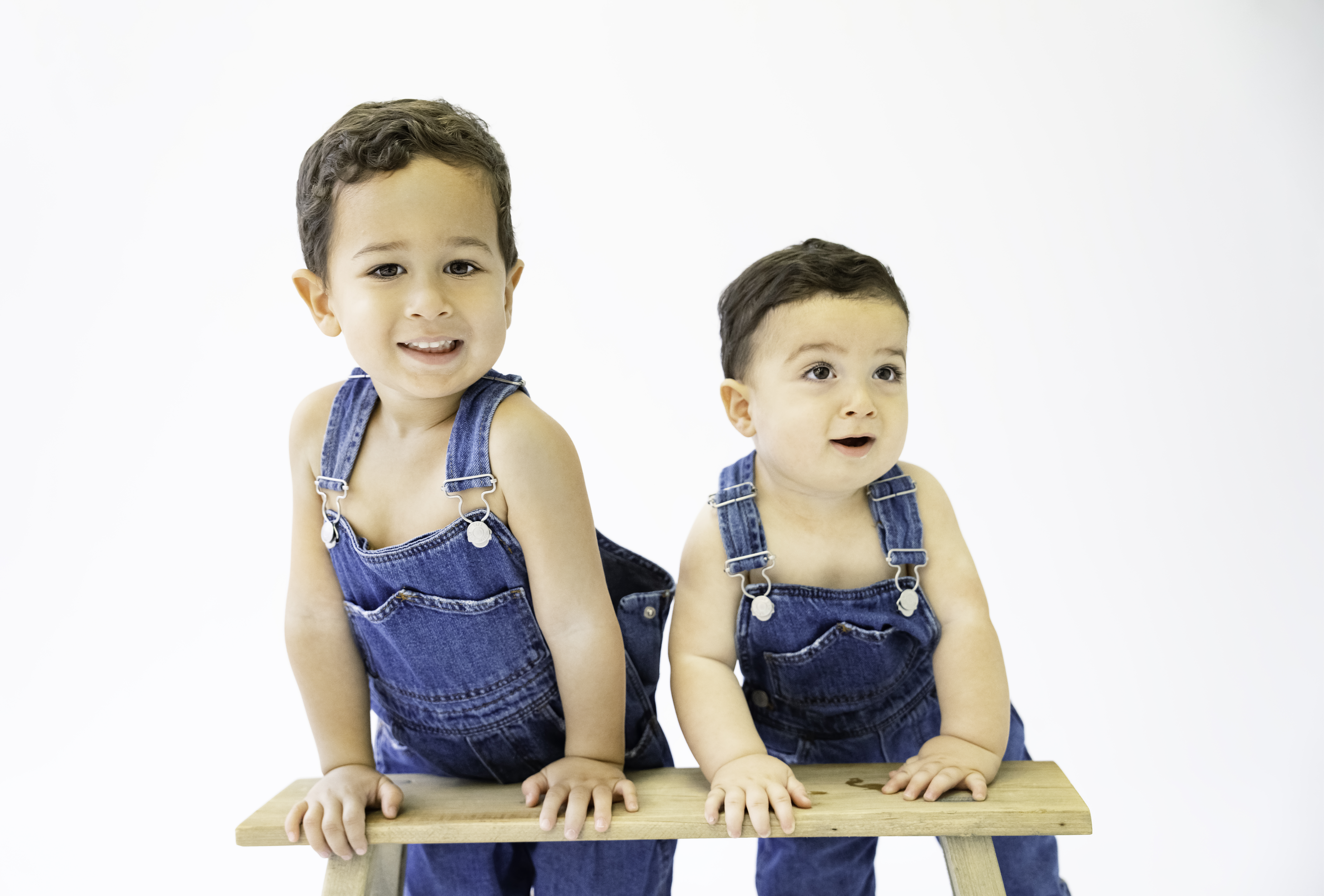 Two smiling toddlers in overalls