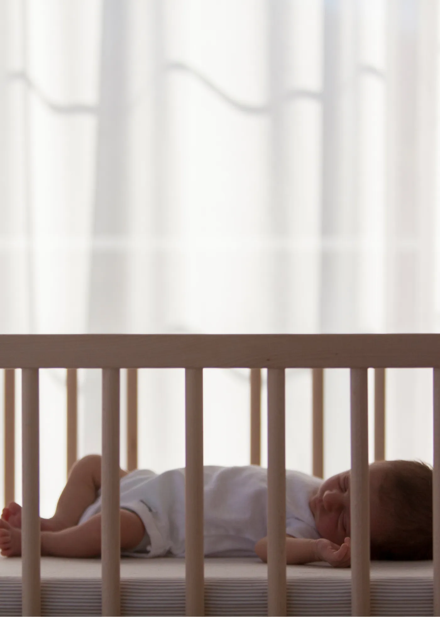 Baby sleeping on their back in a crib