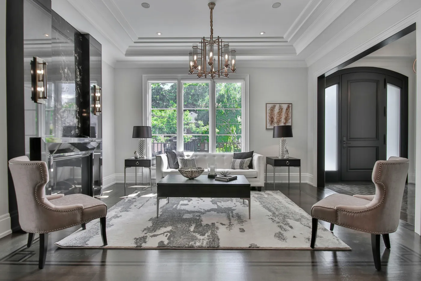 Formal living room with a marble fireplace, tufted sofa, and coffered ceiling Formal living room with a marble fireplace, tufted sofa, and coffered ceiling