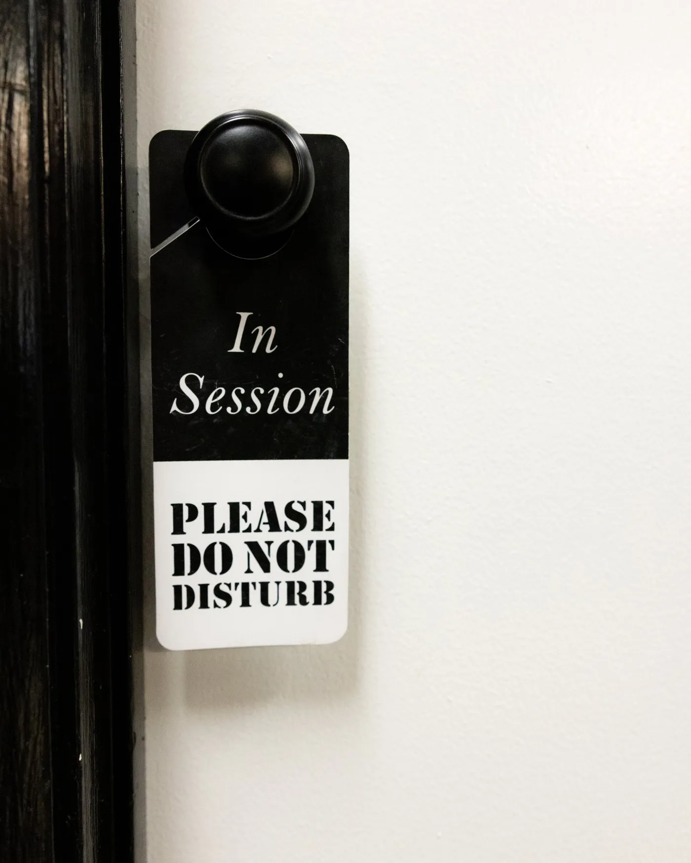In Session, Please Do Not Disturb sign hanging on a suite door