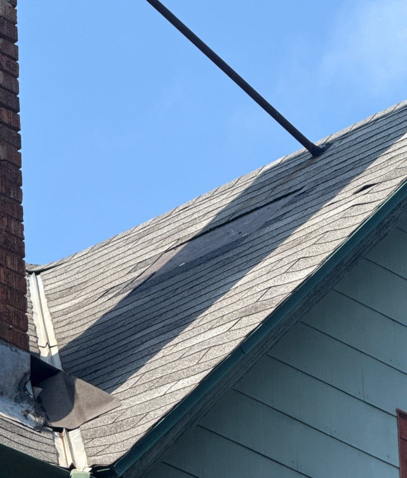 Roof slope meeting a sided dormer wall where a leak repair was made