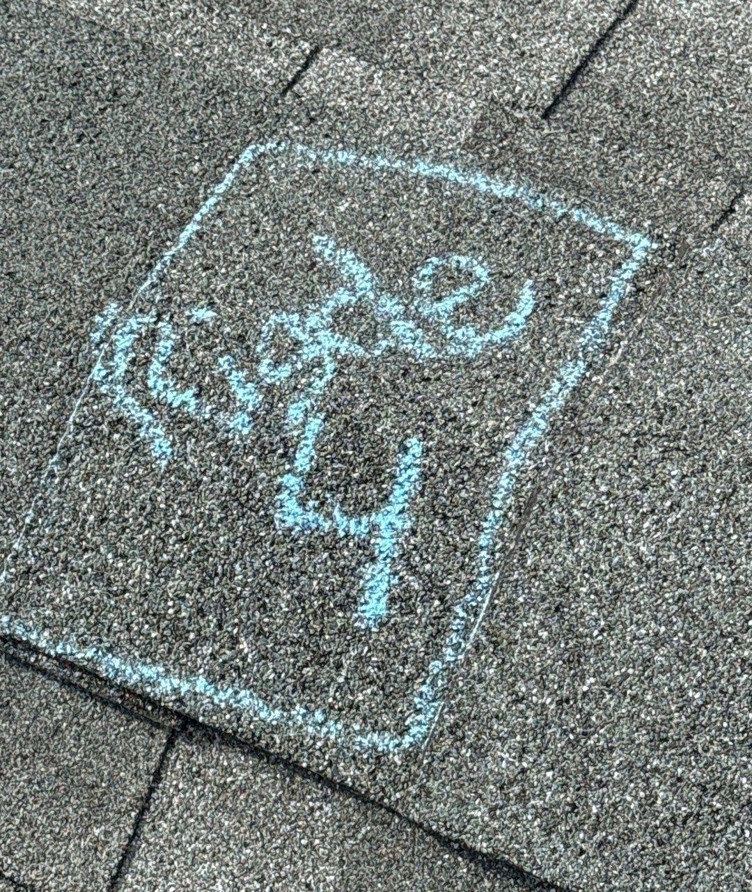 Dark gray ridge cap shingle with a blue chalk box labeled Ridge 4