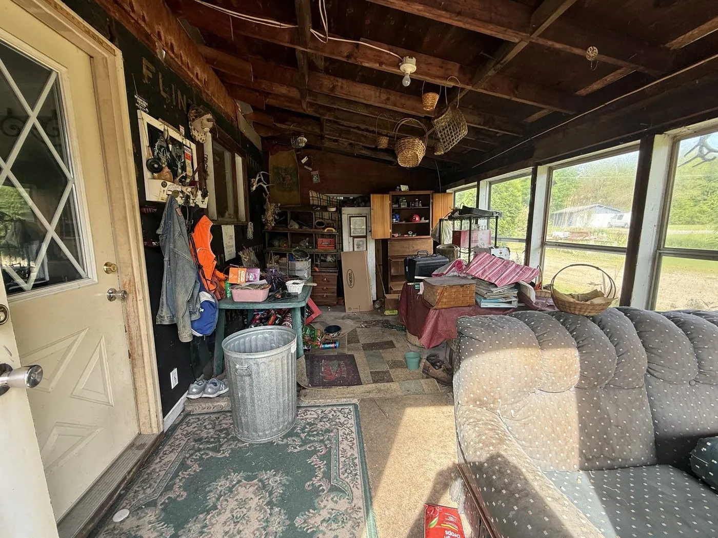 The same sunroom on possession day, packed with furniture and junk