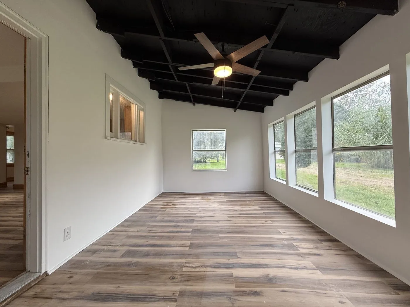 Sunroom after the turnover — cleared, new floors and fresh paint