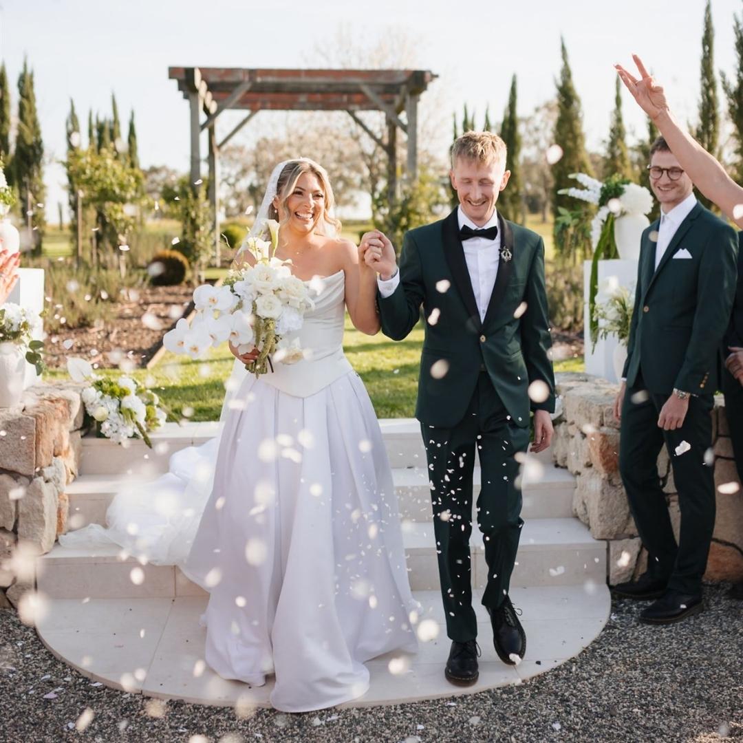 Newlyweds walking through confetti after their ceremony