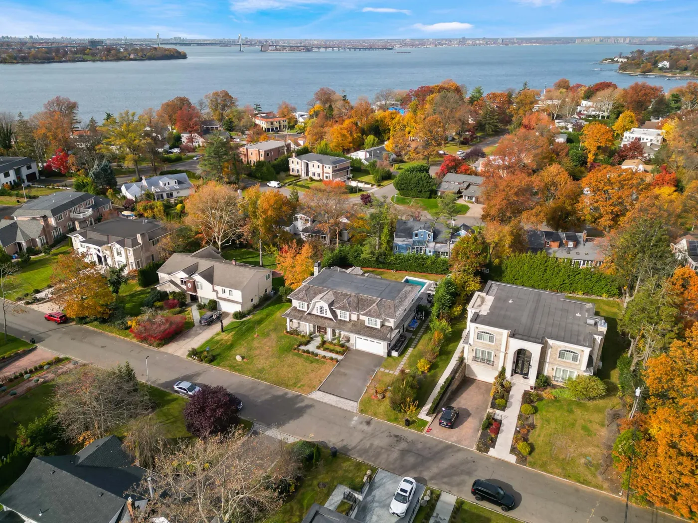 Aerial view over a North Shore neighbourhood in autumn, the water of the Sound beyond the trees