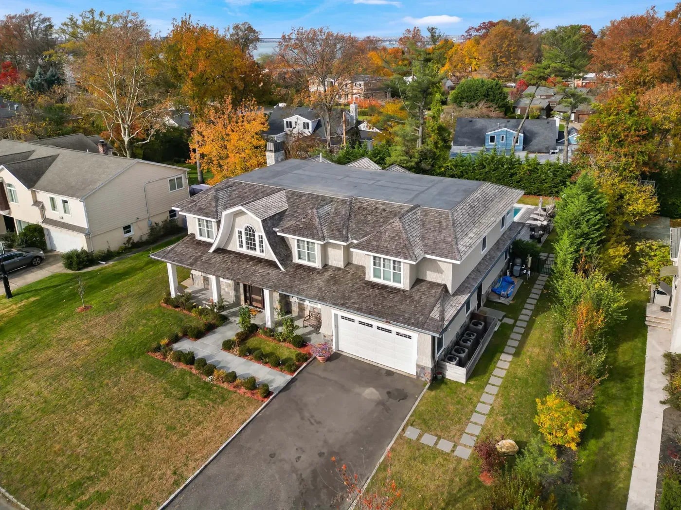 A gambrel-roofed Prestige home seen from above in its North Shore neighbourhood, autumn trees around it
