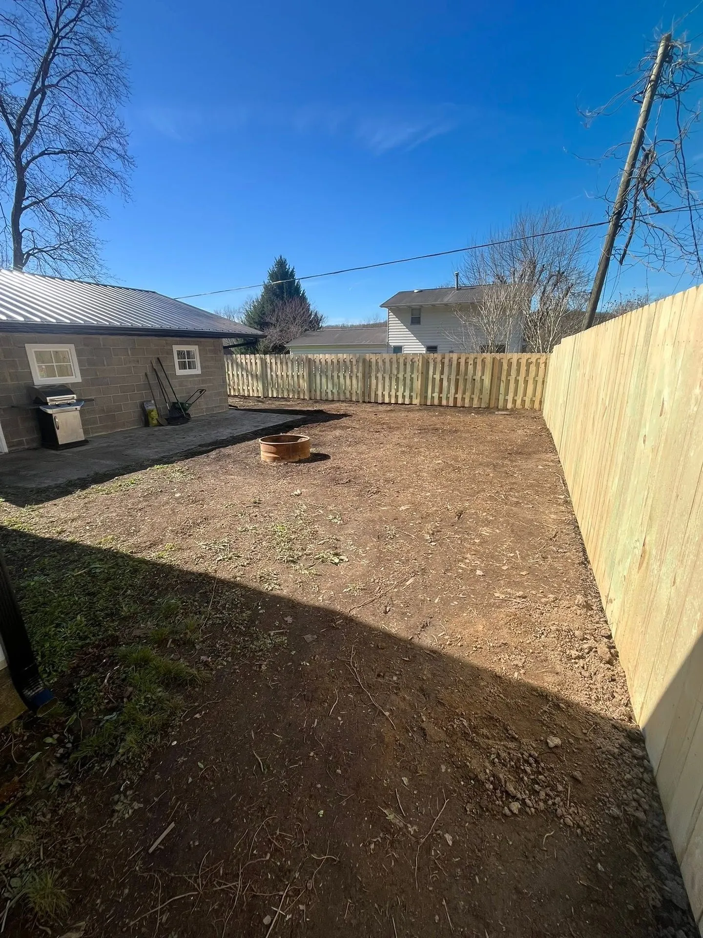 A yard graded smooth and level along a fence line