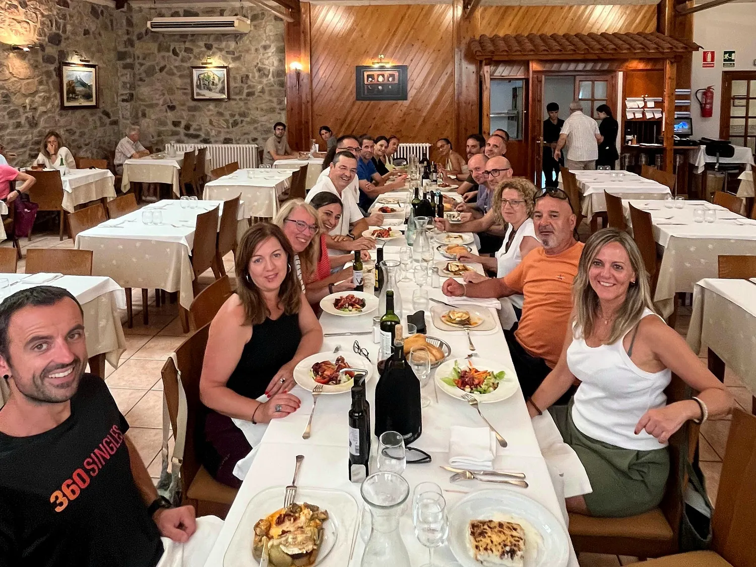 Grupo de 360Singles cenando juntos en una mesa larga
