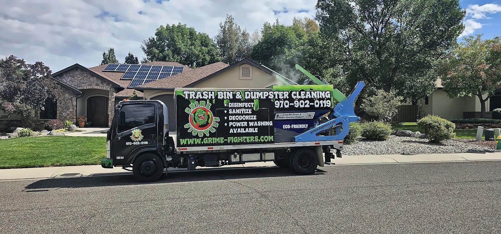 Grime Fighters trash bin and dumpster cleaning truck parked at the curb in front of a home