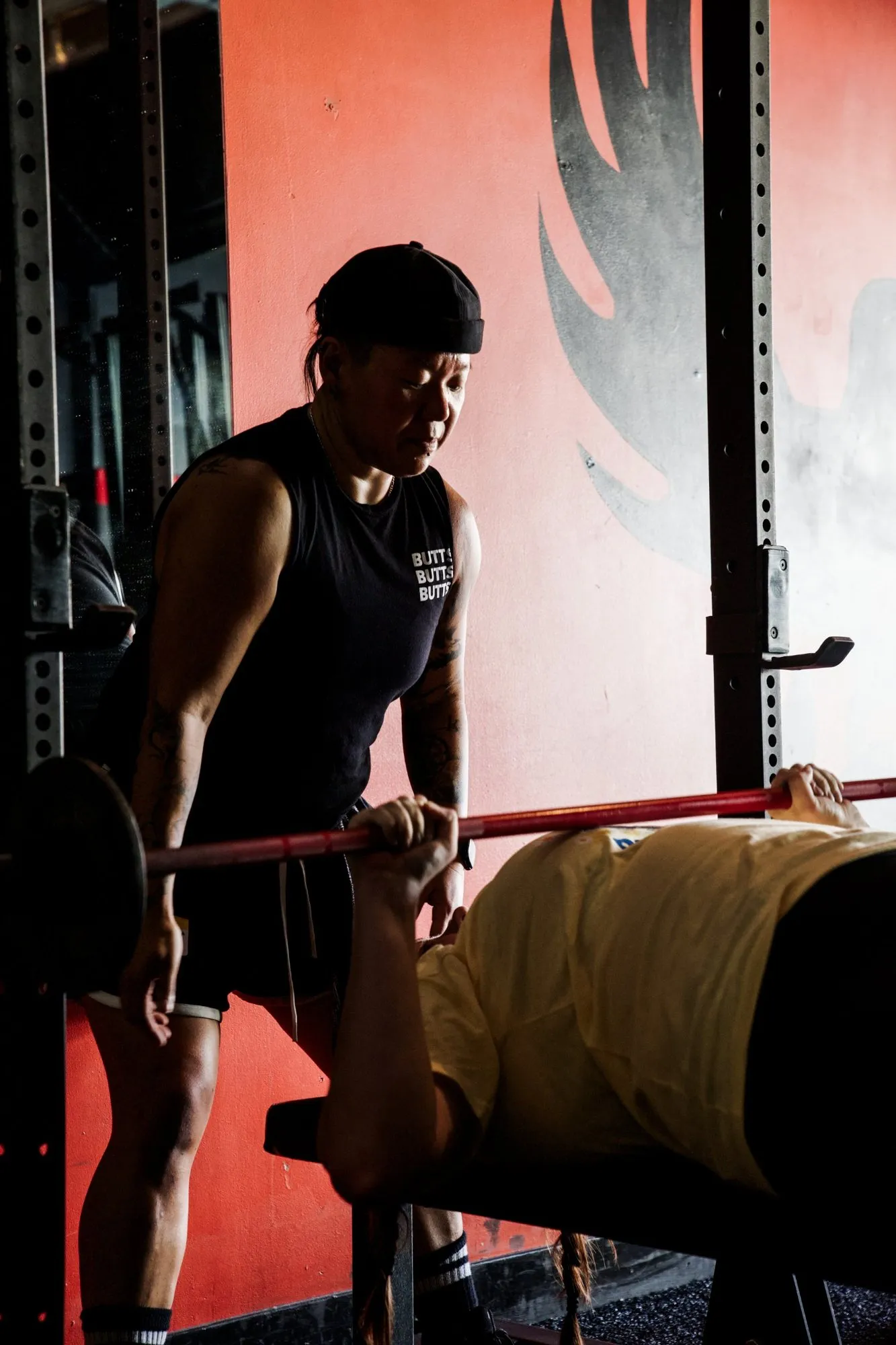 A coach spotting a member on the bench press