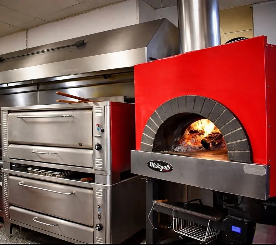 The Lock's red Italian wood-fired oven, burning inside the kitchen