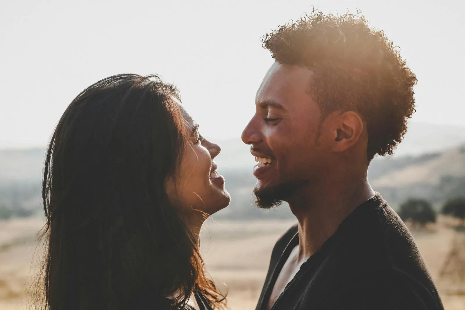 A couple smiling at each other at sunset
