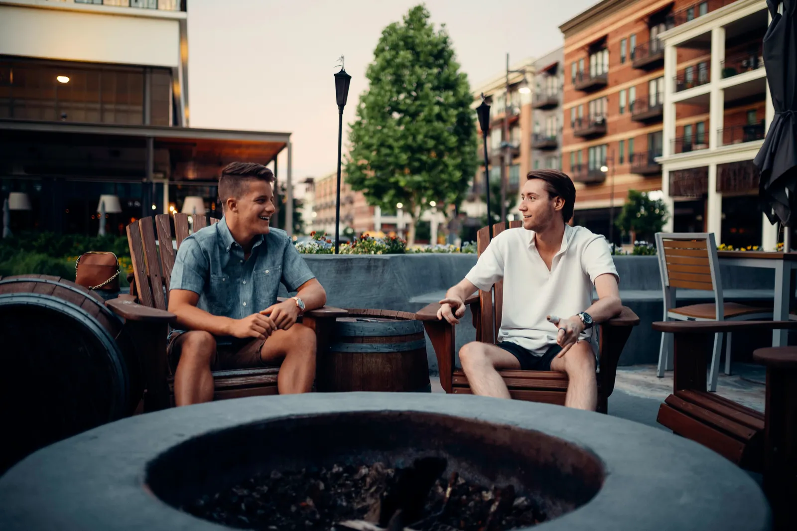 Two people talking at an outdoor table in a downtown business district