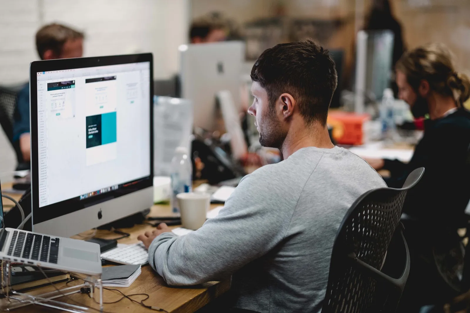 Designer reviewing a website layout on a desktop computer