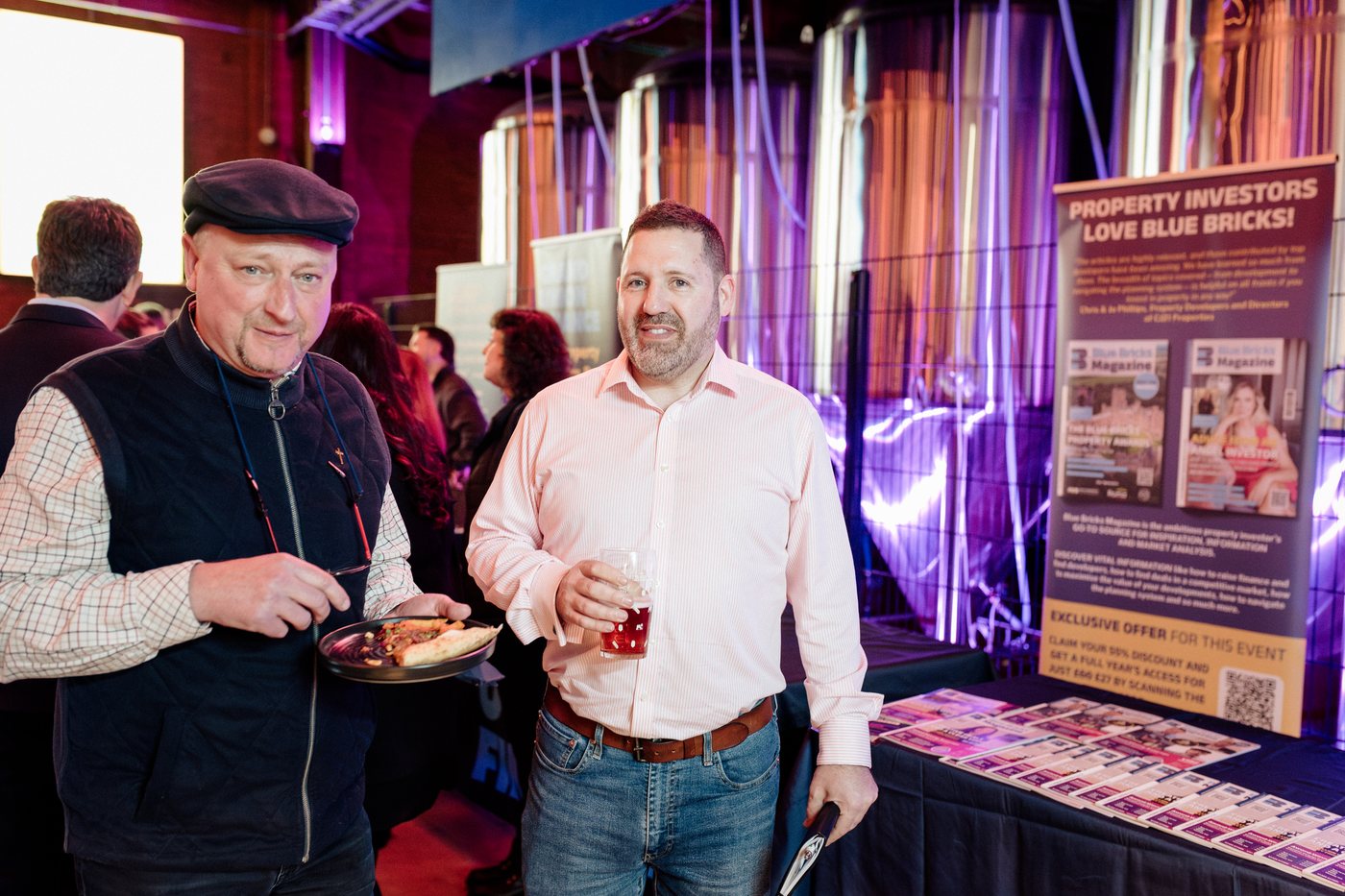 Two guests talking by the Blue Bricks stand at UK Homes Network LIVE Birmingham