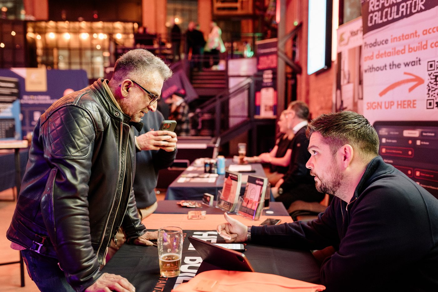 Property professionals talking across an exhibitor table at UK Homes Network LIVE Birmingham