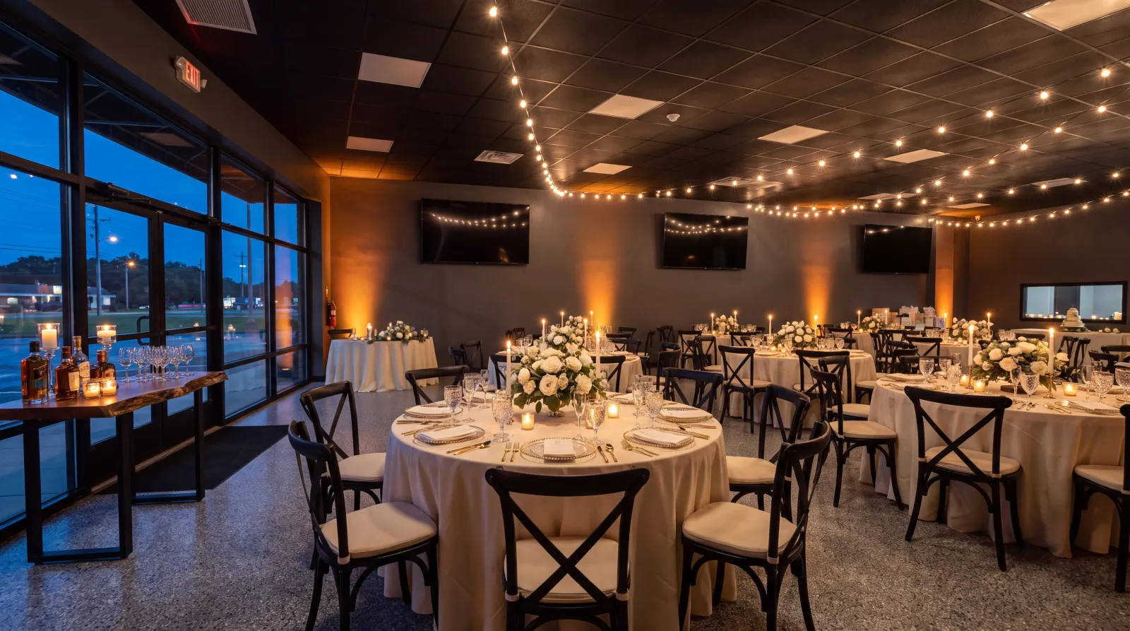 The Commons event room in Plains, PA set with round tables, cream linens and a cake table for an evening celebration