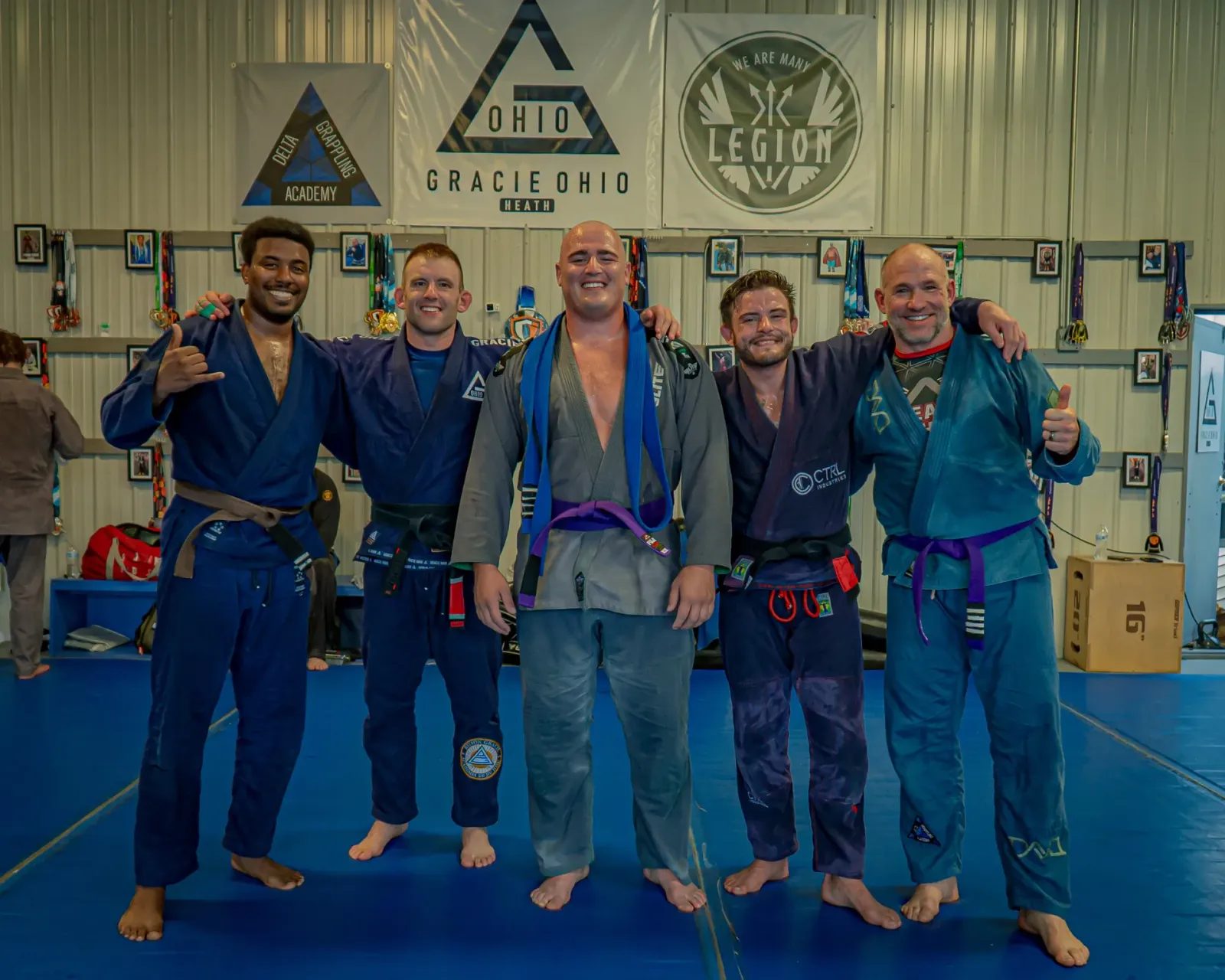 Coaches and upper belts at Delta Grappling Academy under the Gracie Ohio and Legion Project banners