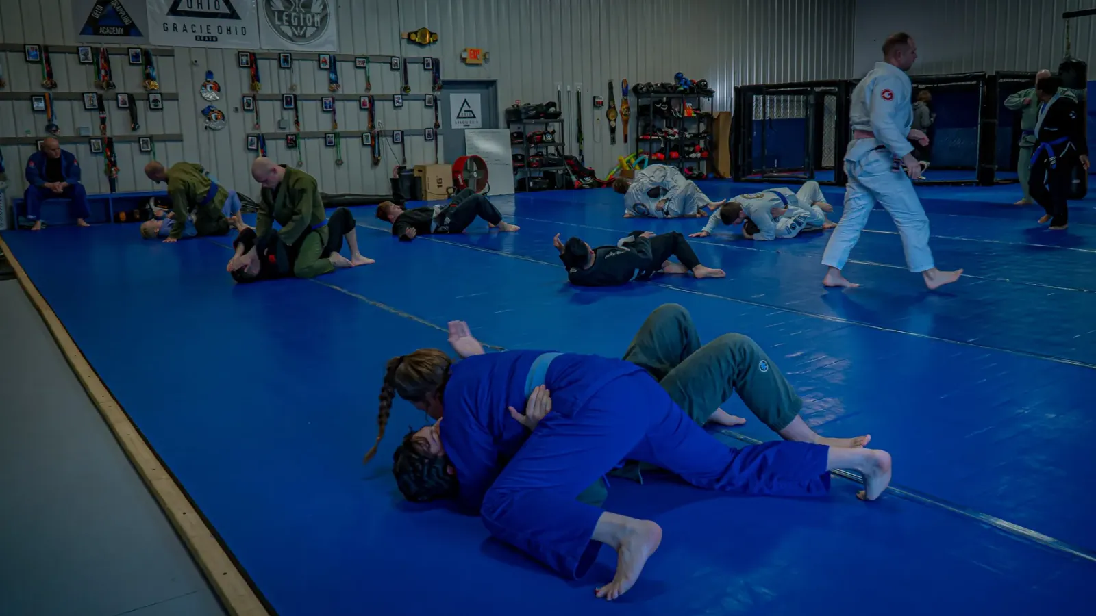 Students rolling across the mats during class at Delta Grappling Academy