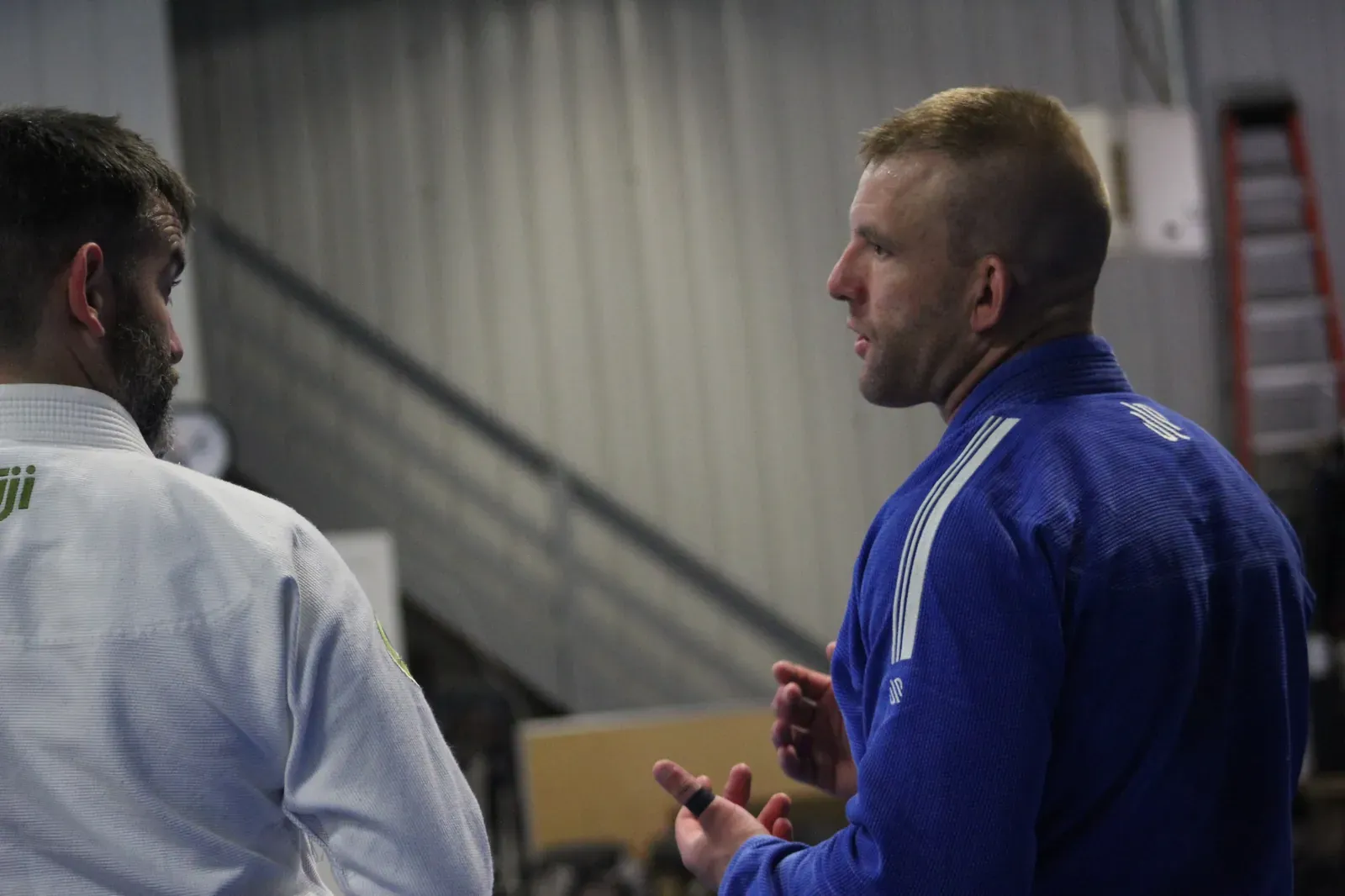 A coach talking with a student between rounds at Delta Grappling Academy