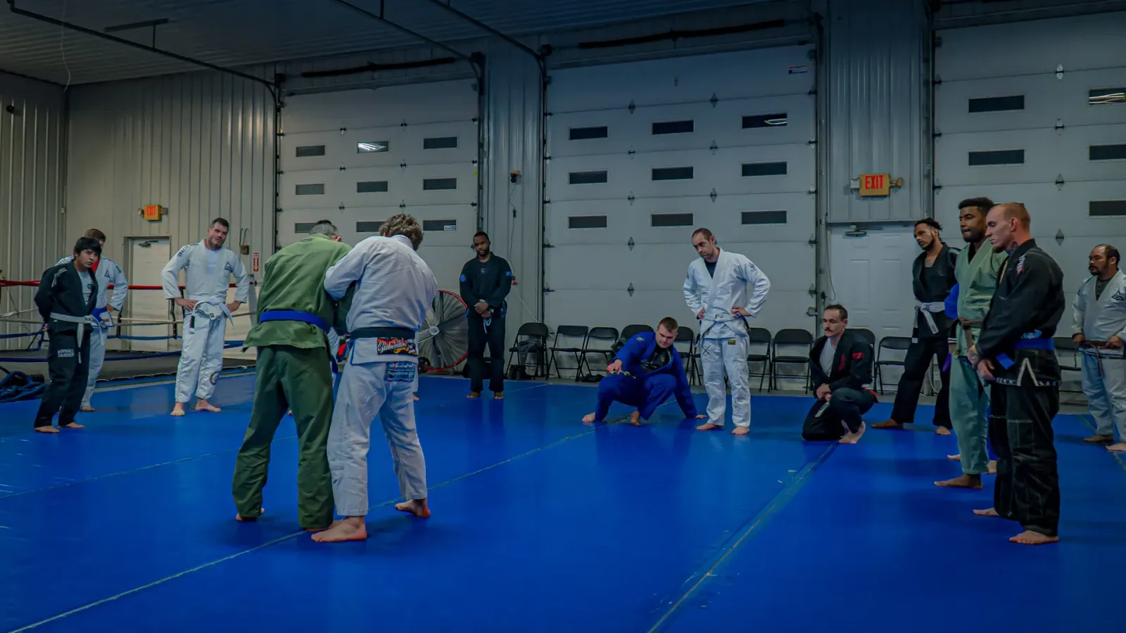 An adult jiu-jitsu class gathered on the mat for instruction at Delta Grappling Academy