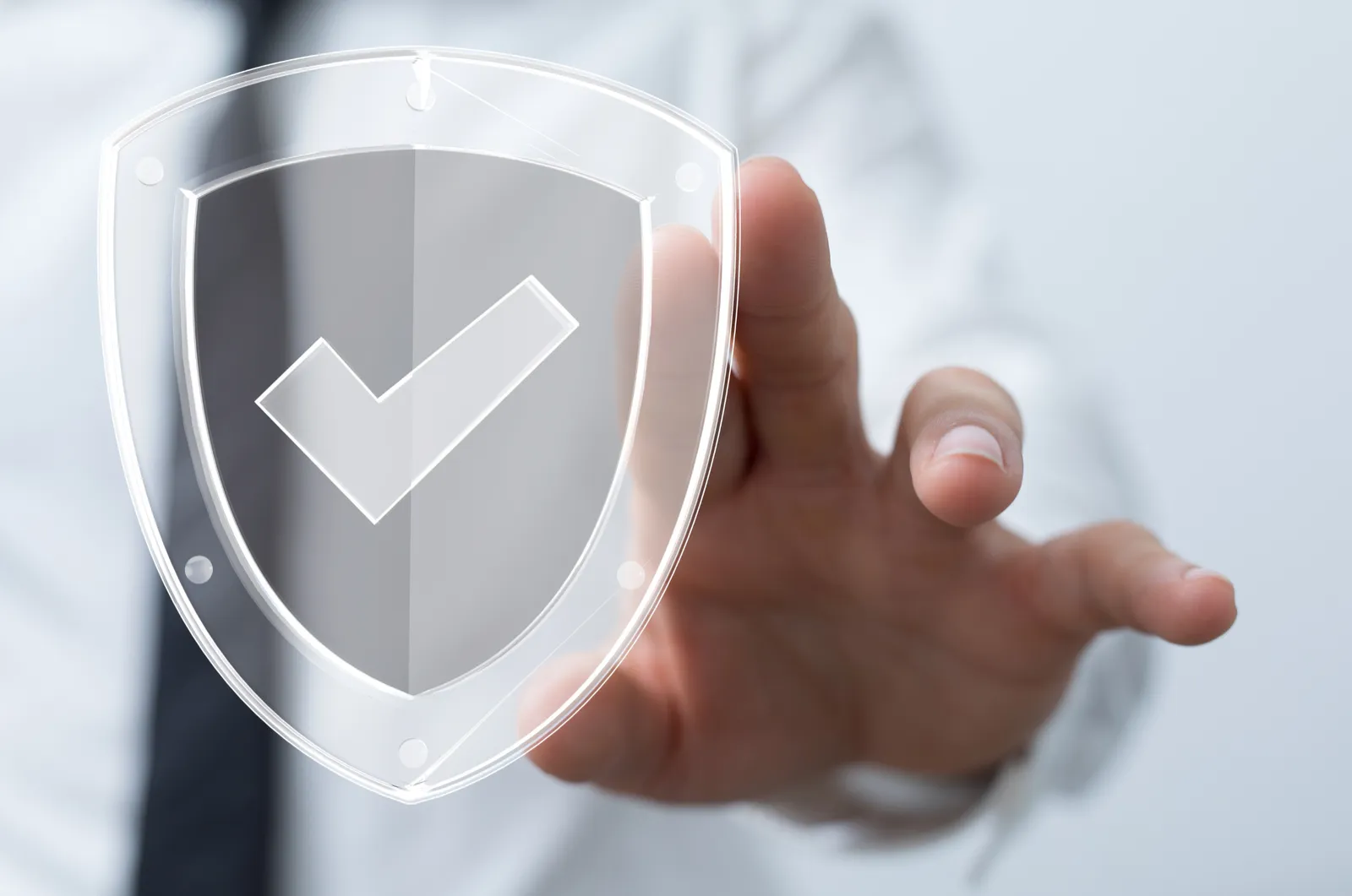 A hand touching a glass shield icon with a check mark