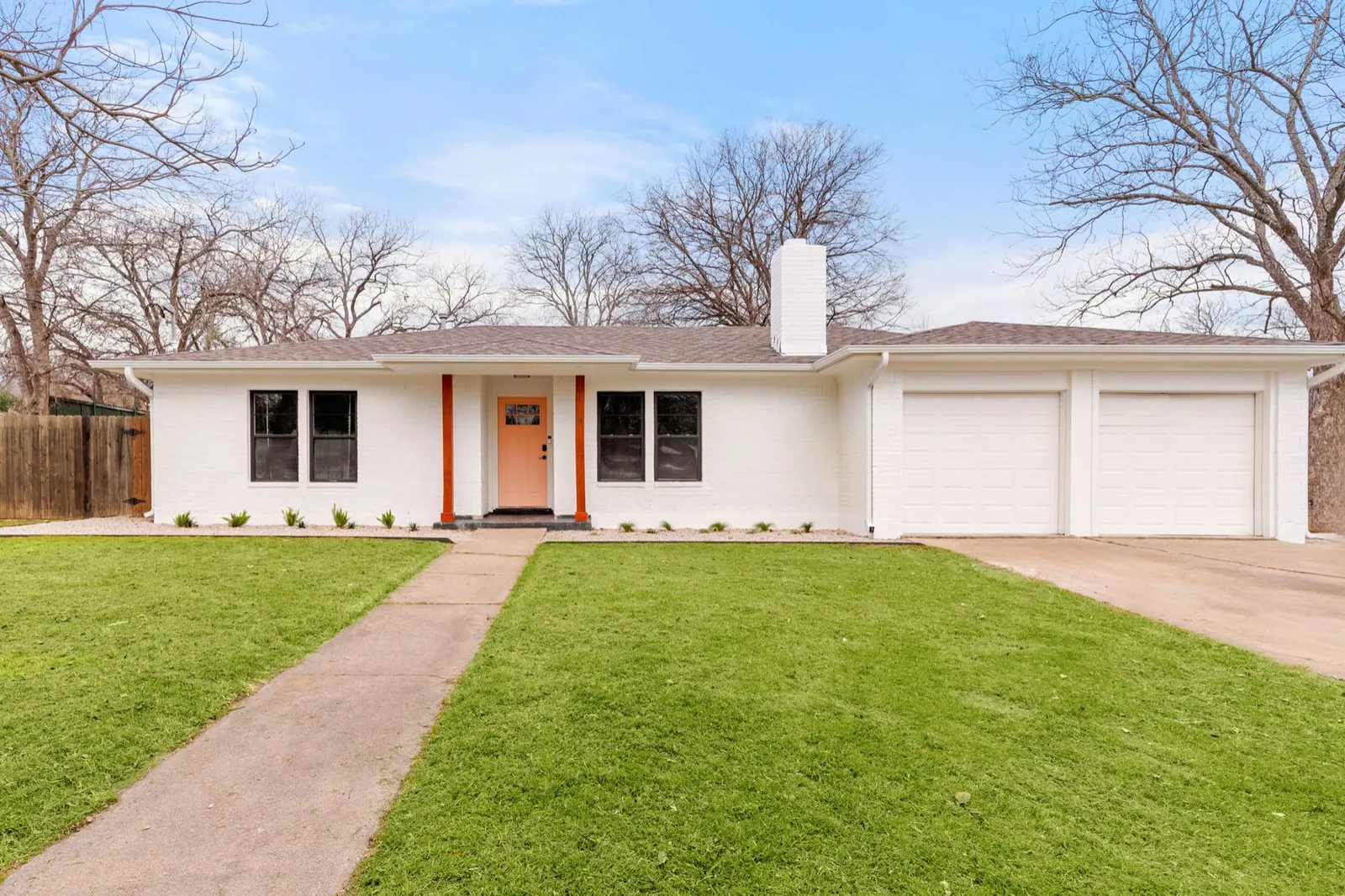Exterior after: painted white brick, new front door and posts, fresh landscaping