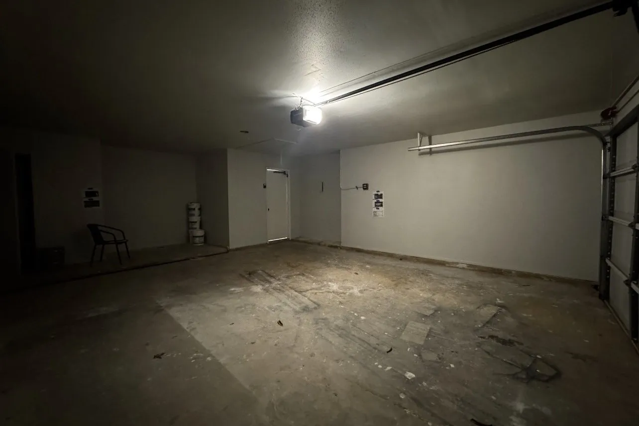 Garage before: empty two-car garage with a stained concrete slab