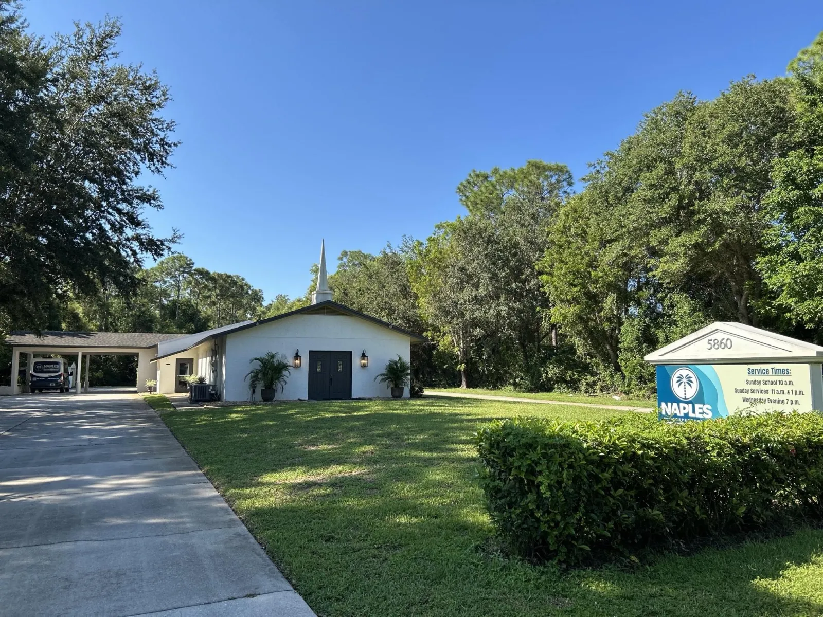 Naples Independent Baptist Church from Autumn Oaks Lane, with the spire, the lawn and the church sign