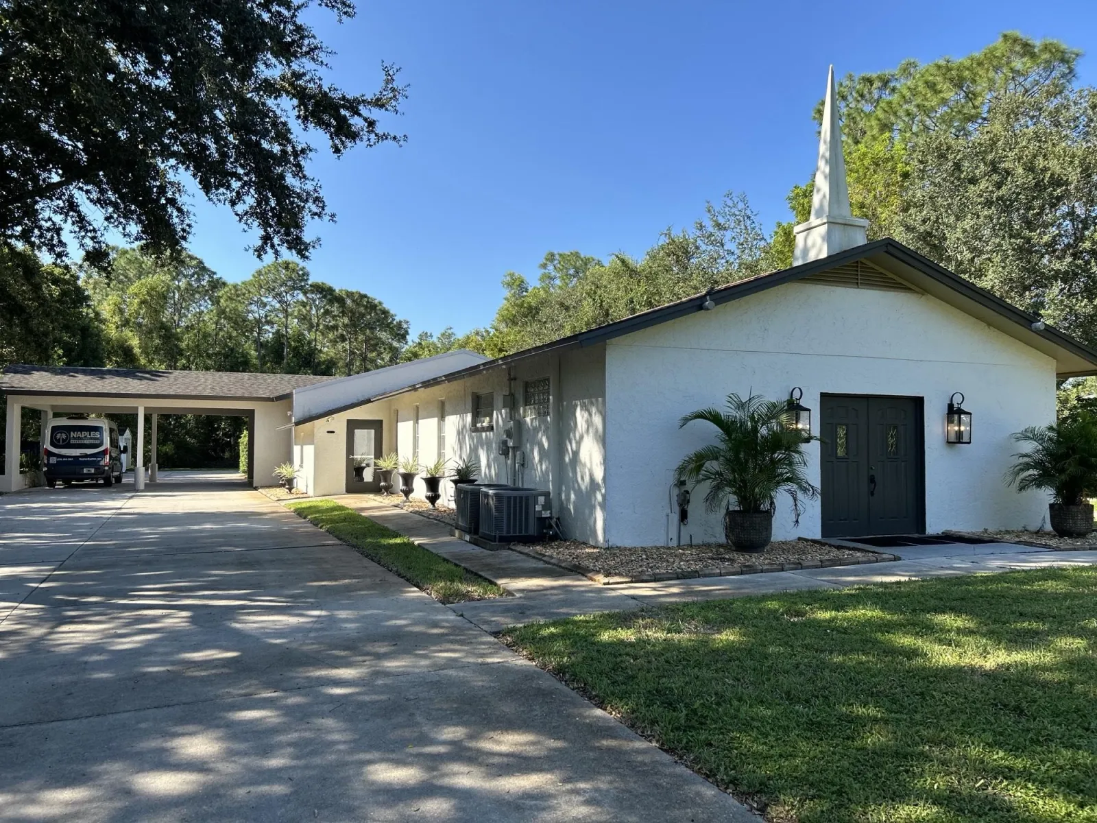 The front of Naples Independent Baptist Church, the spire and the green doors from the drive