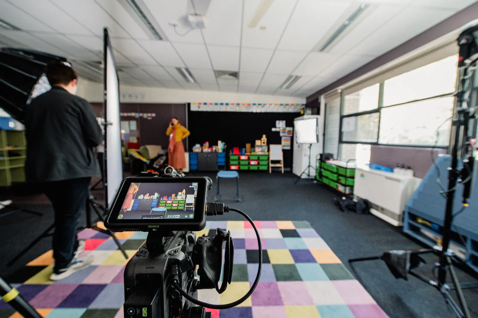 Crew and camera equipment beside classroom windows during the Passions & Pathways shoot