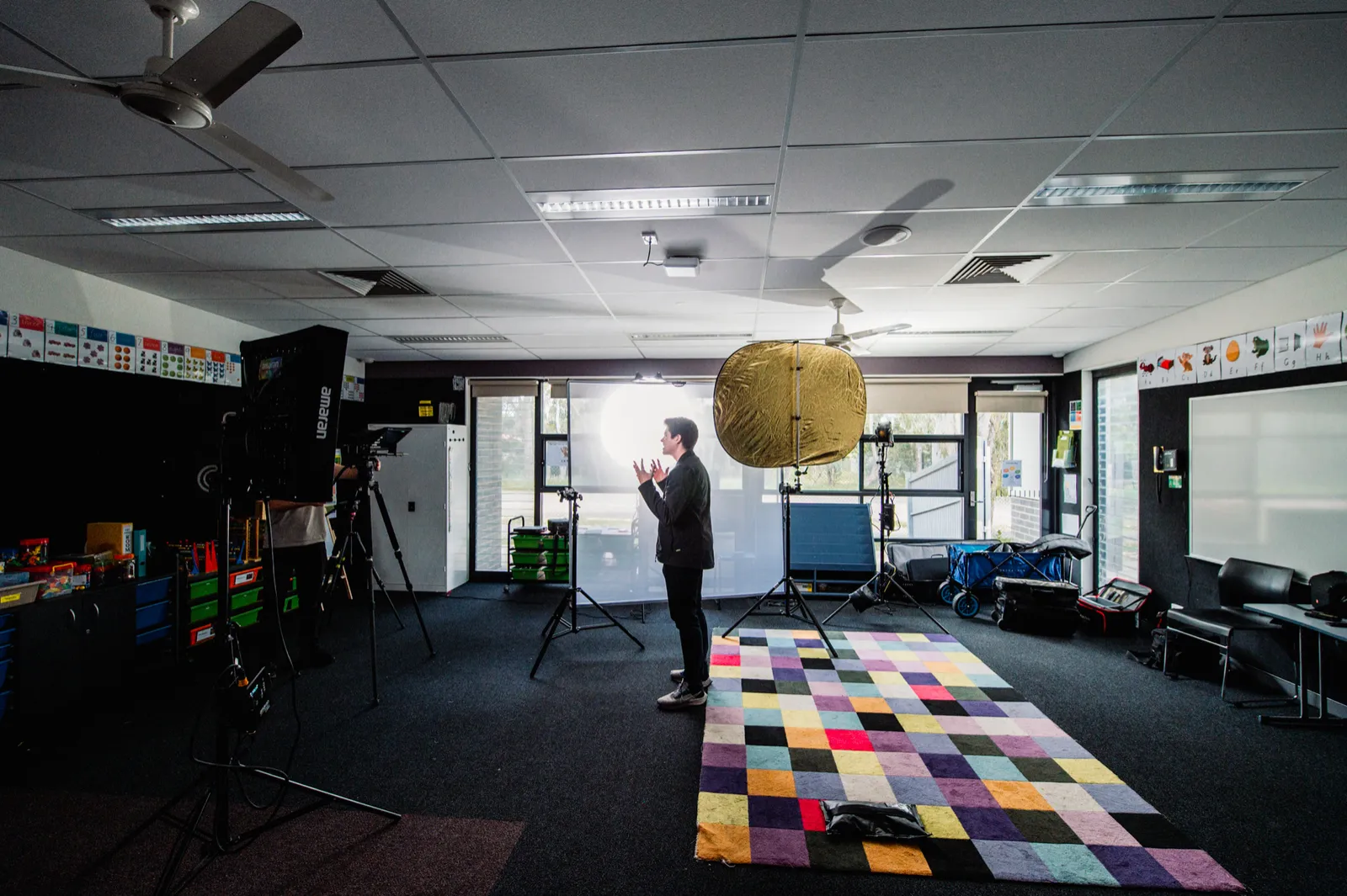 Wide view of the classroom interview set with lighting and camera equipment