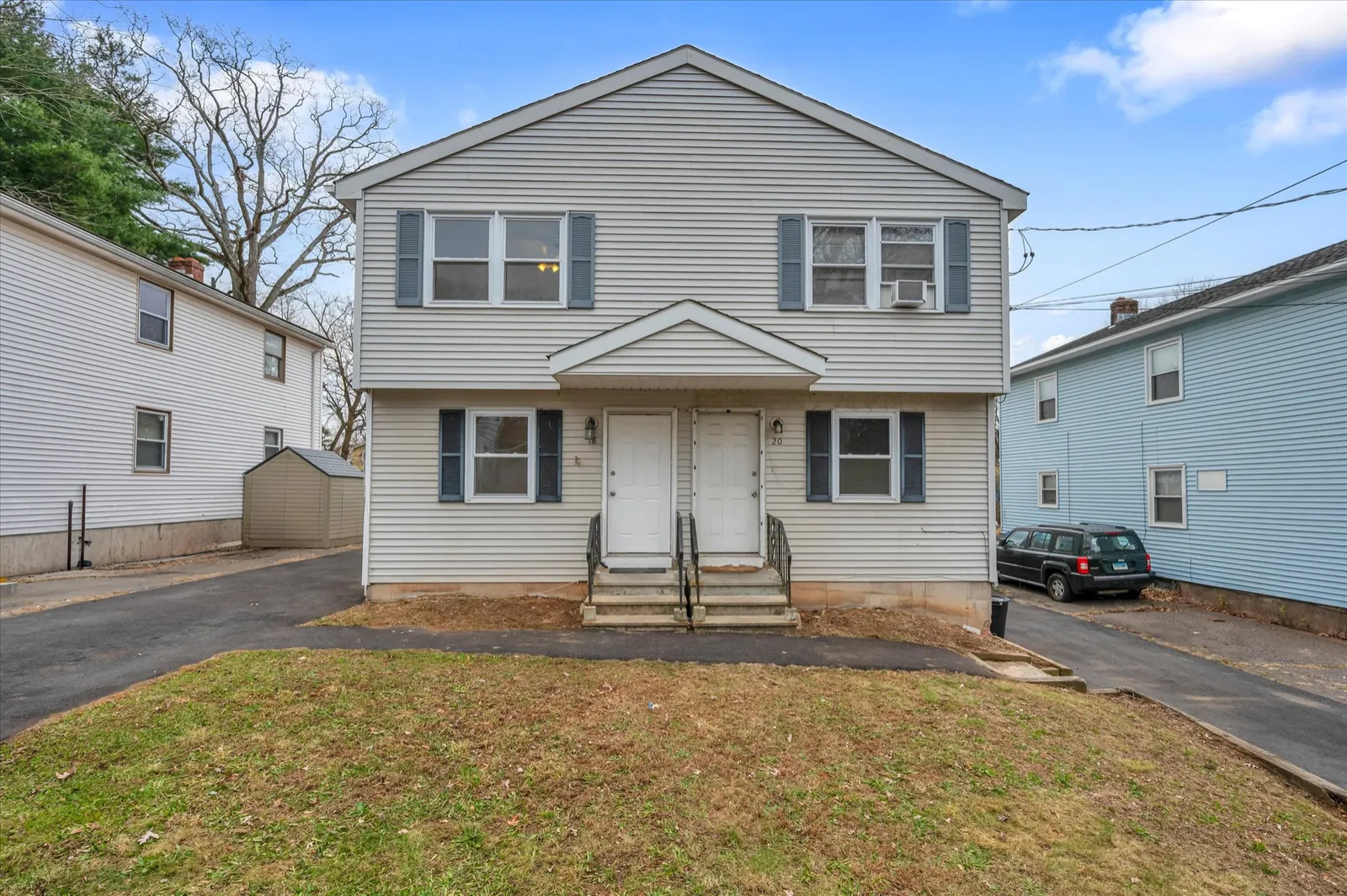 Gray vinyl-sided side-by-side duplex at 18 Chalmers Street, Manchester, CT, with two front entries, blue shutters and driveways on both sides