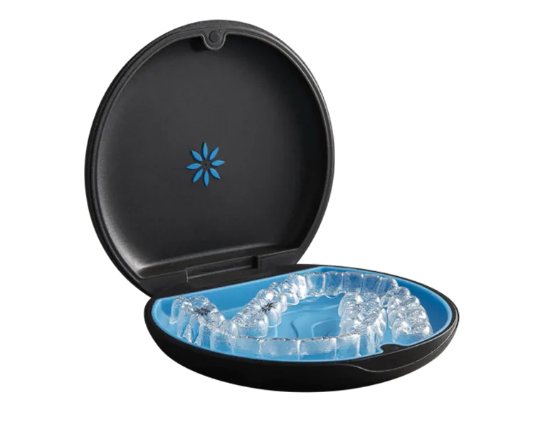 Estuche oficial de Invisalign abierto con el juego de alineadores transparentes en su interior