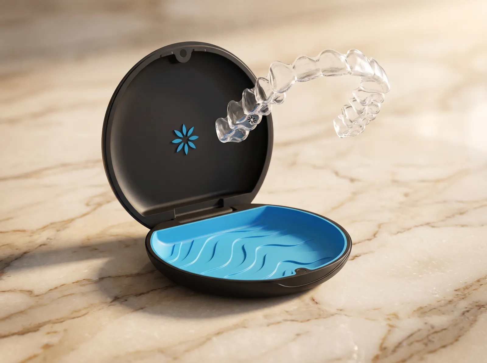 Estuche oficial de Invisalign — clamshell oval negro con interior azul de silicona texturada, alineador transparente saliendo del estuche