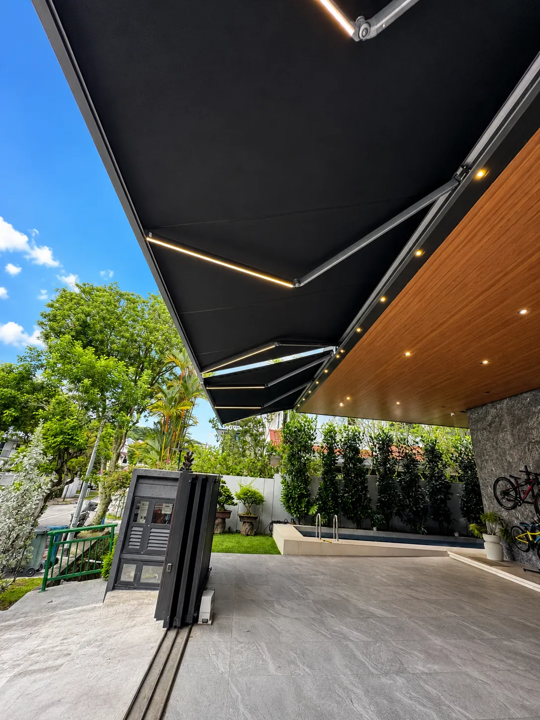 Black motorised cassette awning extended over a landed home entrance