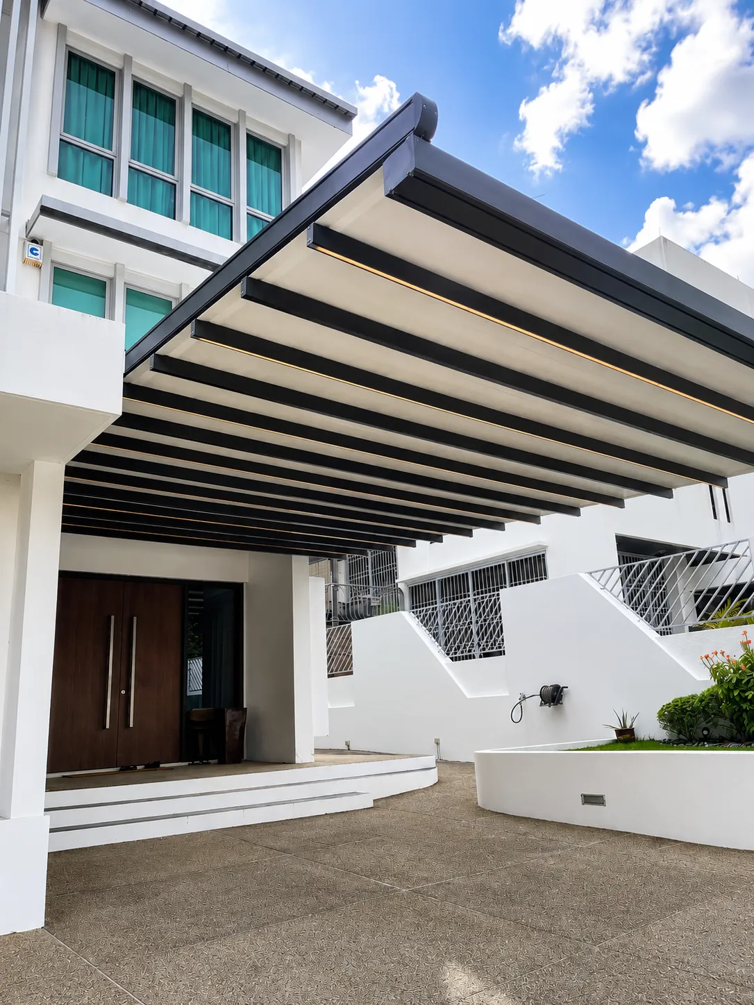 Retractable fabric pergola over a driveway at a landed home