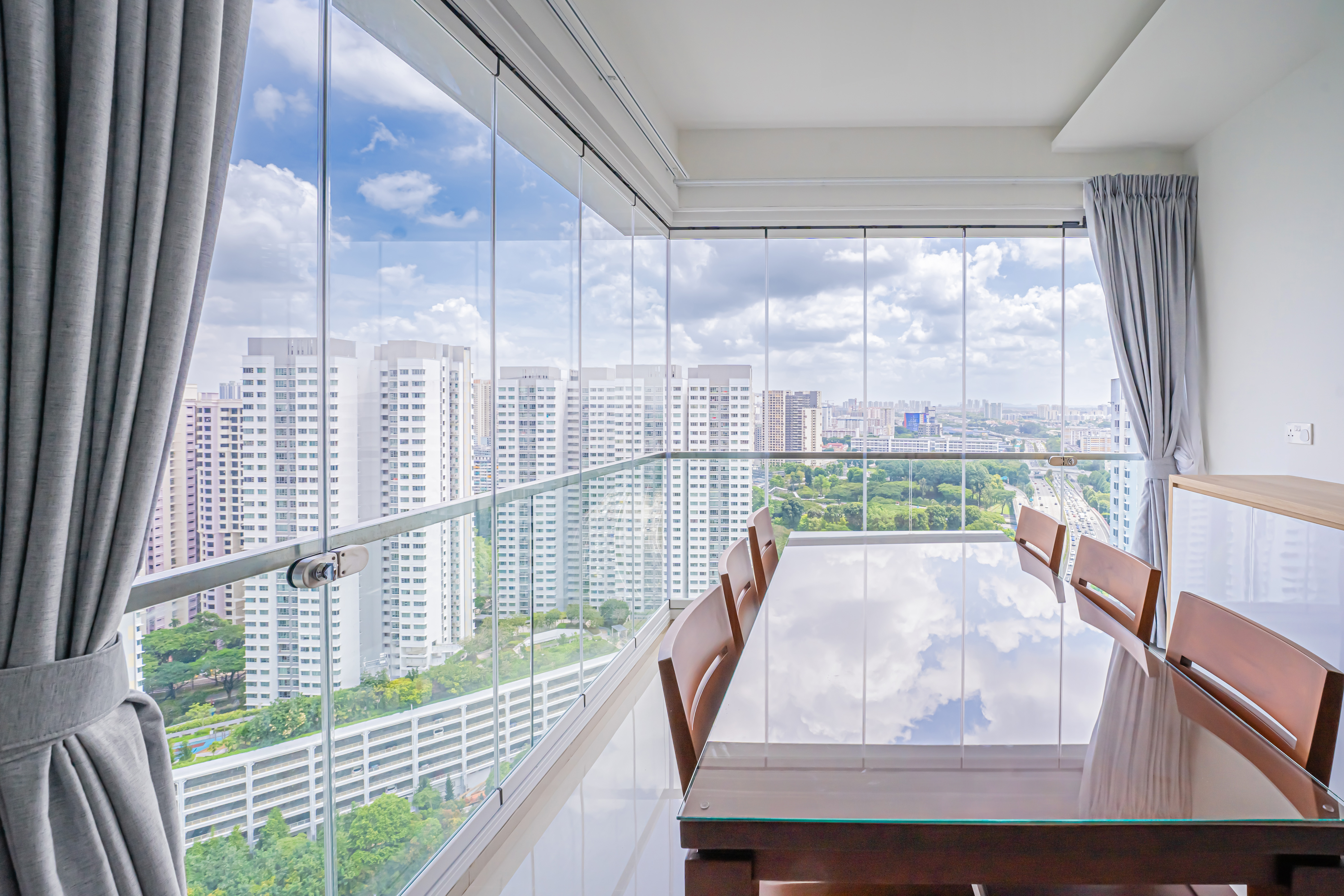 Glazed room with roller blinds and a city view