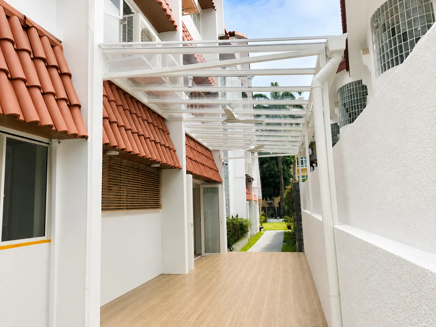 White-framed roof over a walkway beside a tiled roof