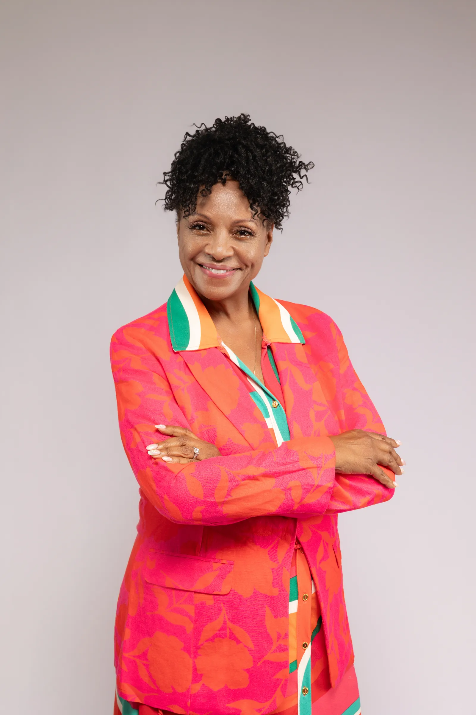 Tanya Scott, arms crossed, in a coral blazer