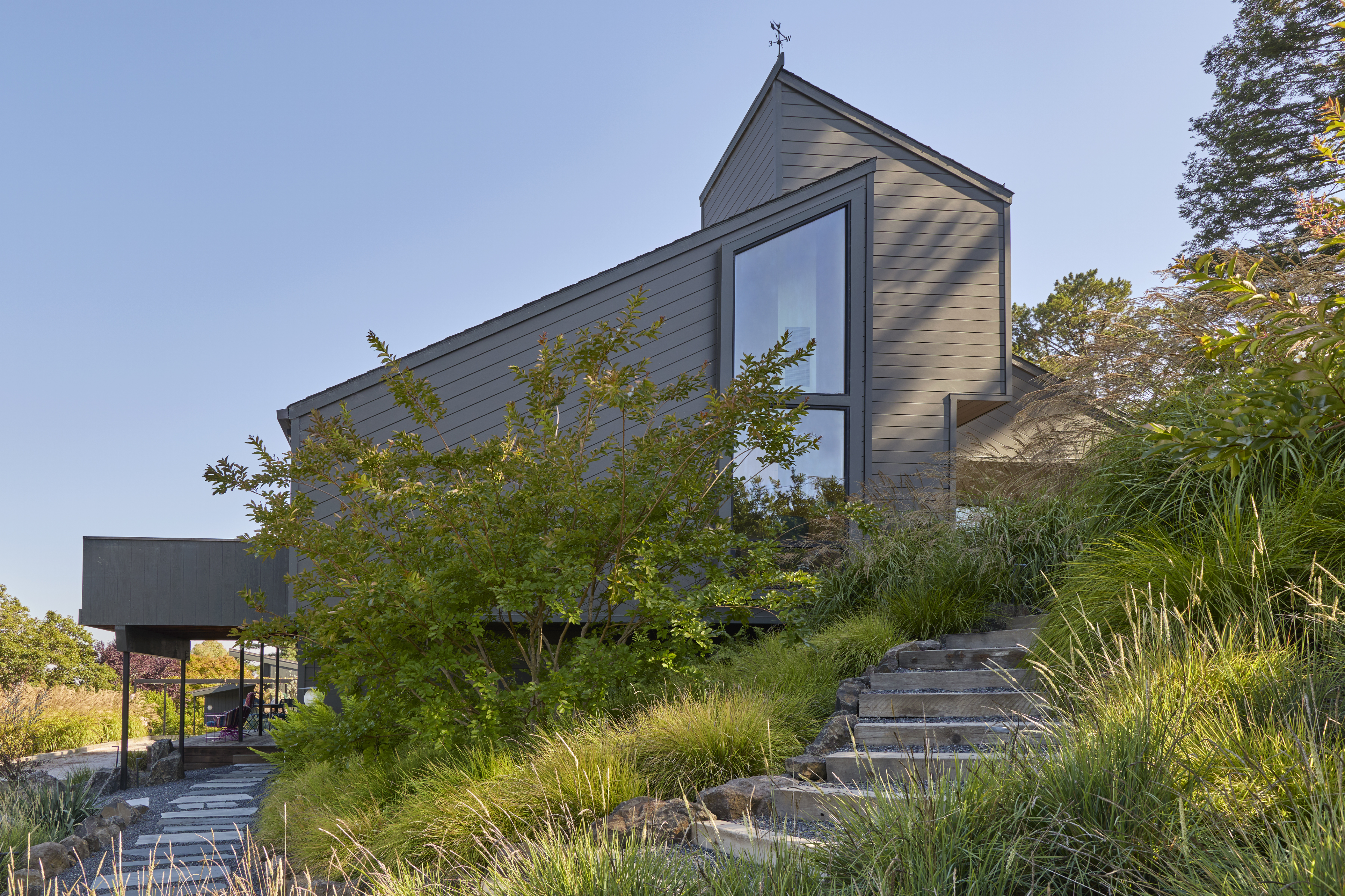 Flagstone patio and pathway with drought tolerant grasses beside a Sebastopol CA home