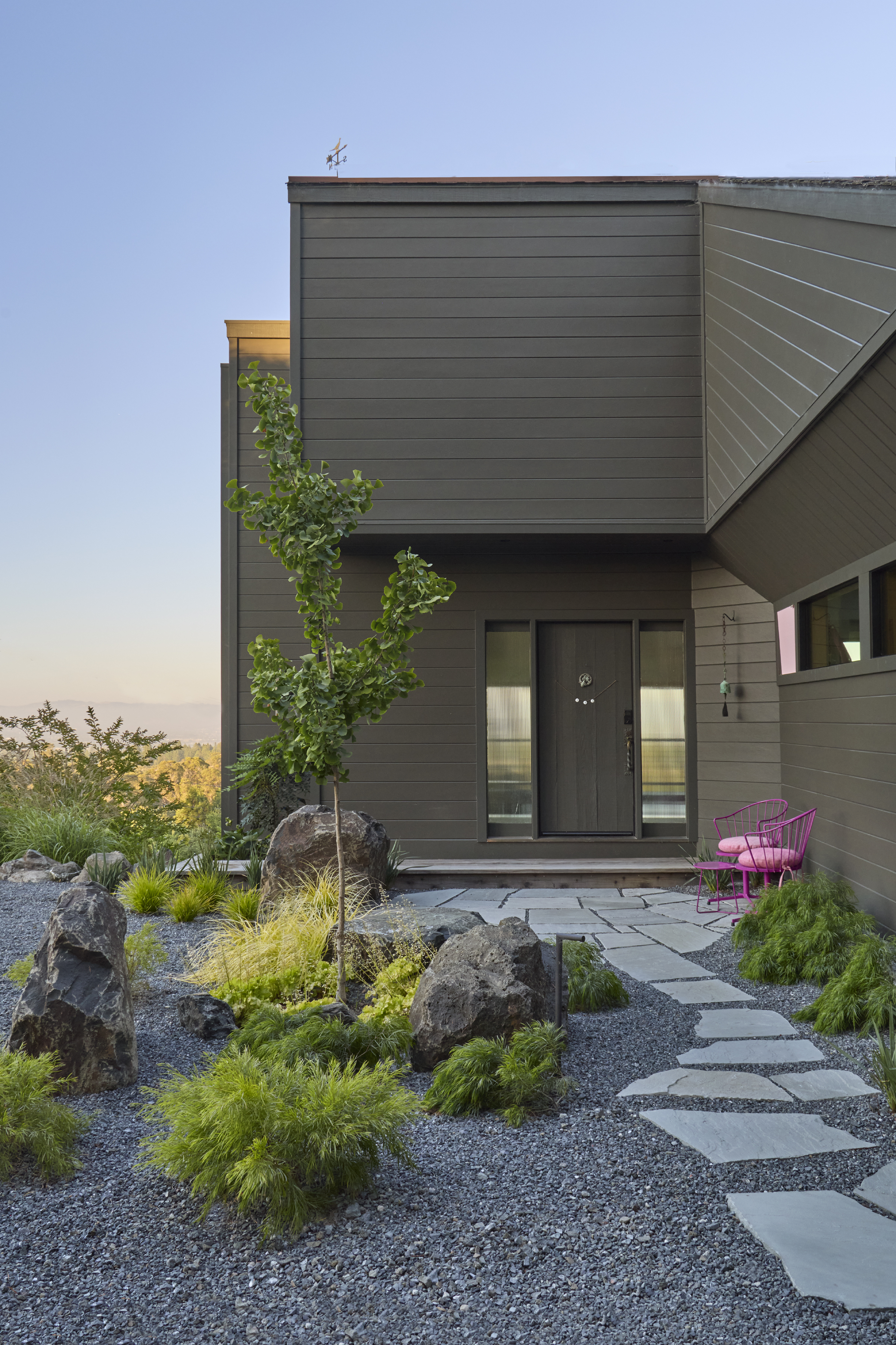 Front door entrance in Sebastopol CA with flagstone walkway, gravel, basalt boulders, ginkgo tree and ornamental grasses by OCL Landscaping