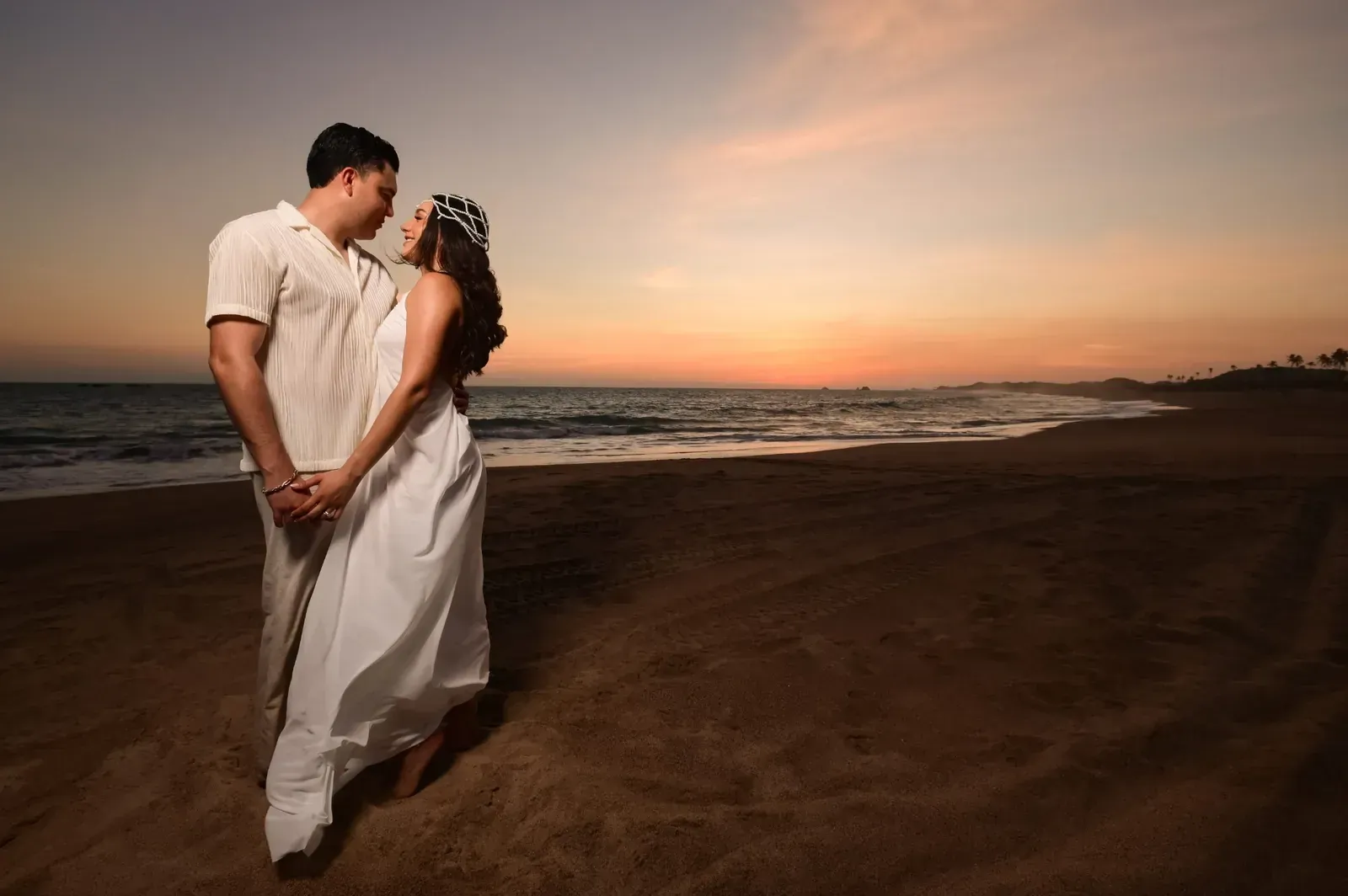 Isamar y Brian abrazados al atardecer, mirándose