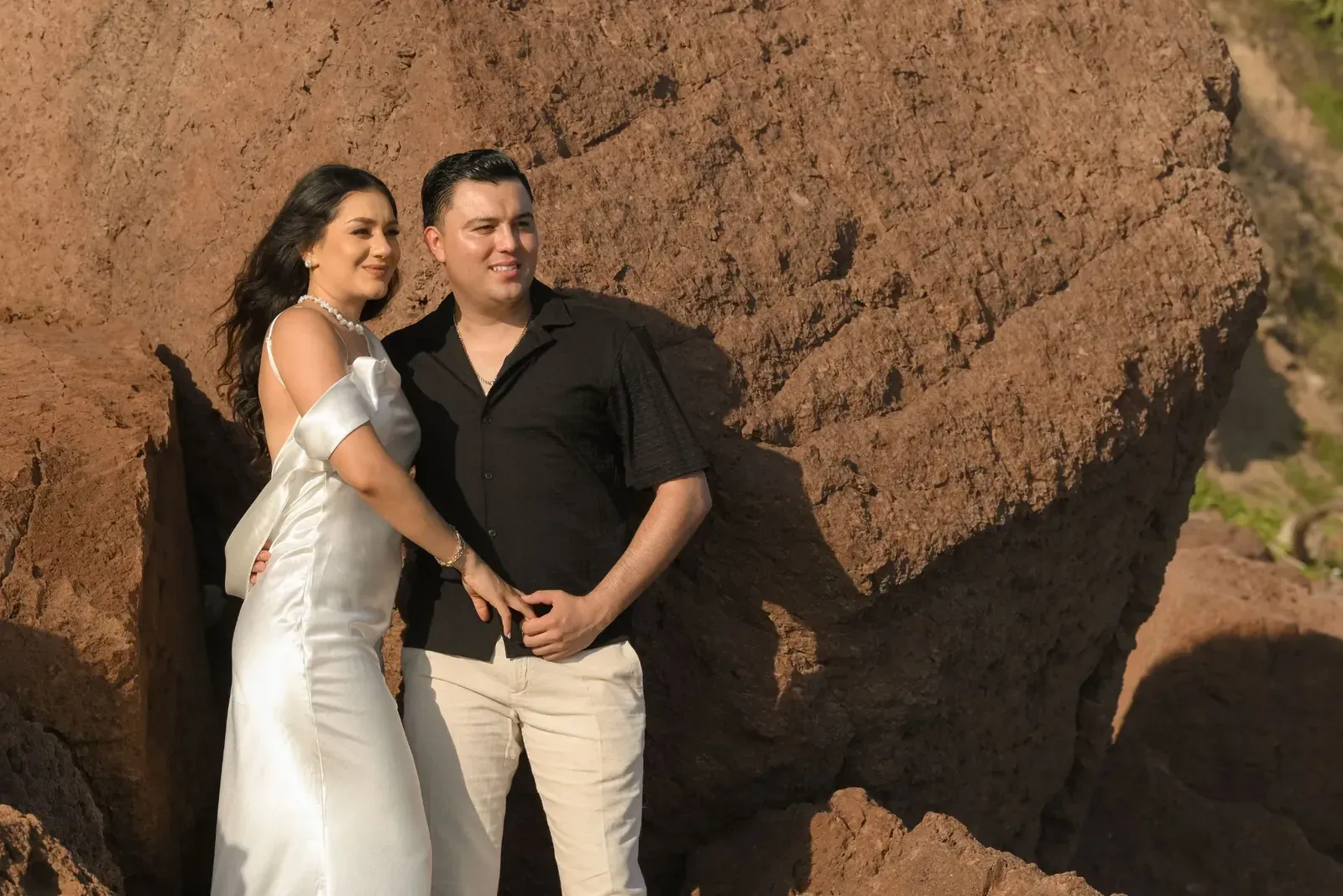 Isamar y Brian abrazados junto a una roca, sonriendo