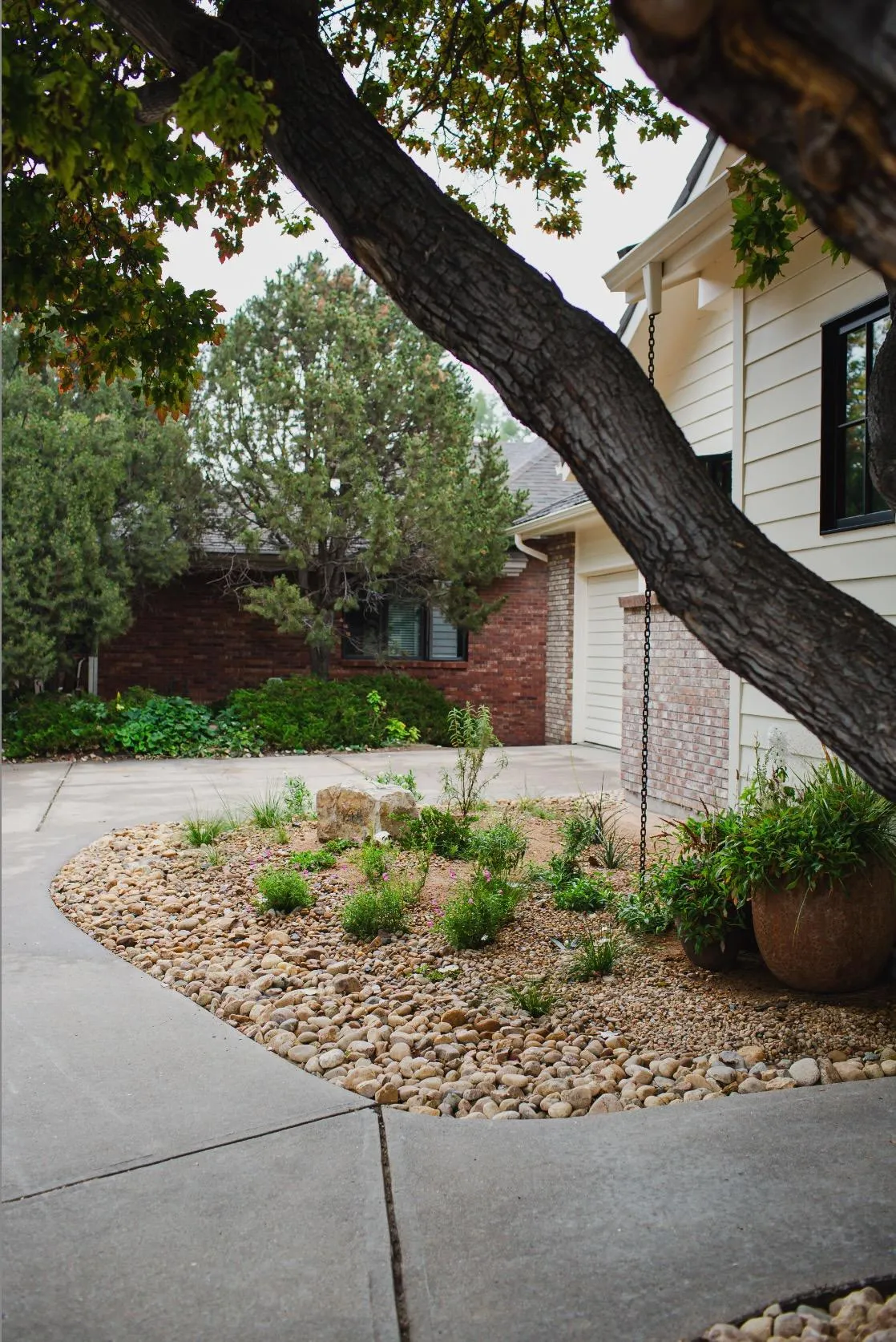 A curved river-rock garden designed and installed by Mother Gardener